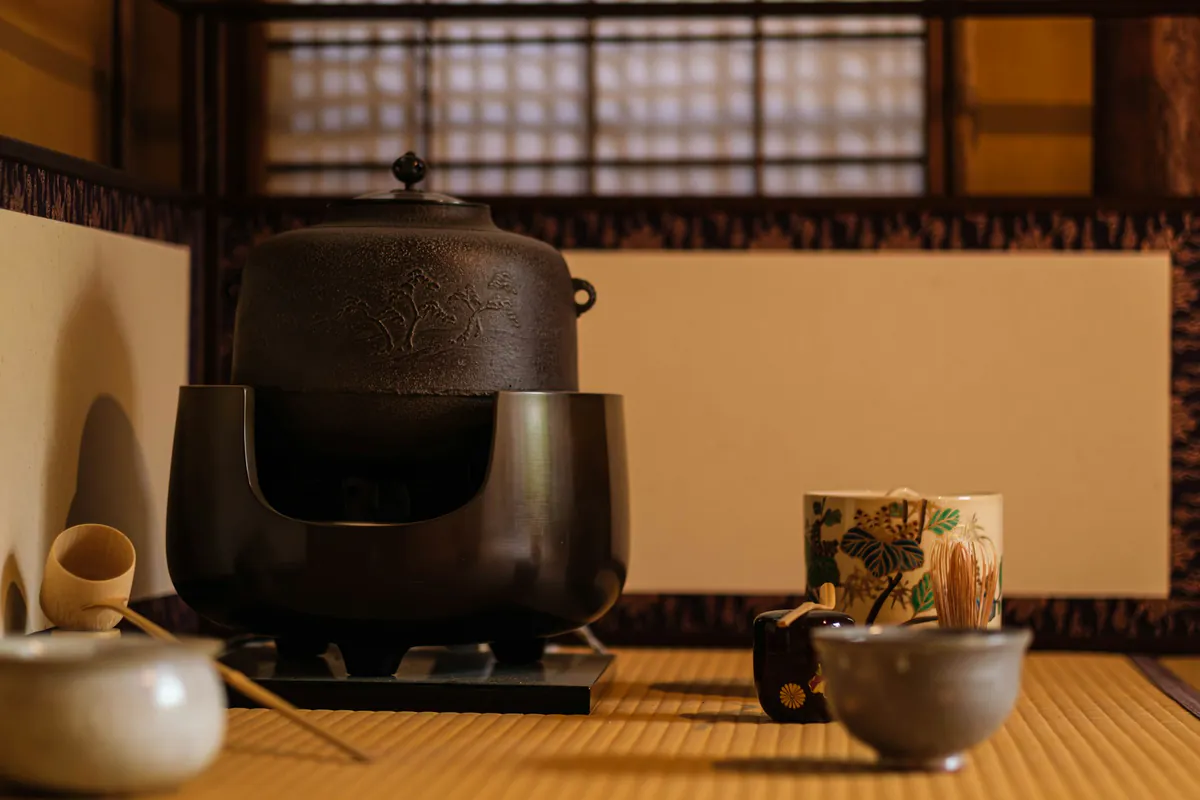 A traditional Japanese tea ceremony setting with a kettle and cups.