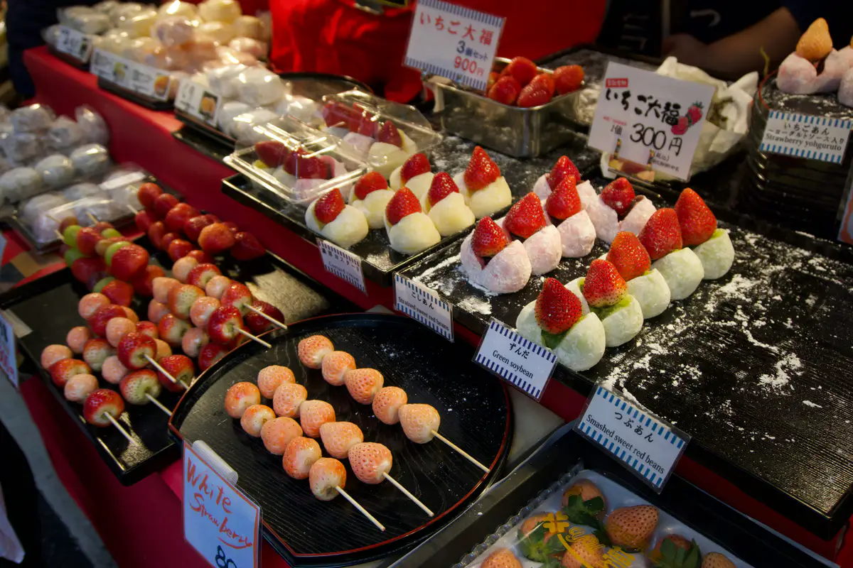 Japanese strawberries and fruit-filled sweets arranged at a market stall.