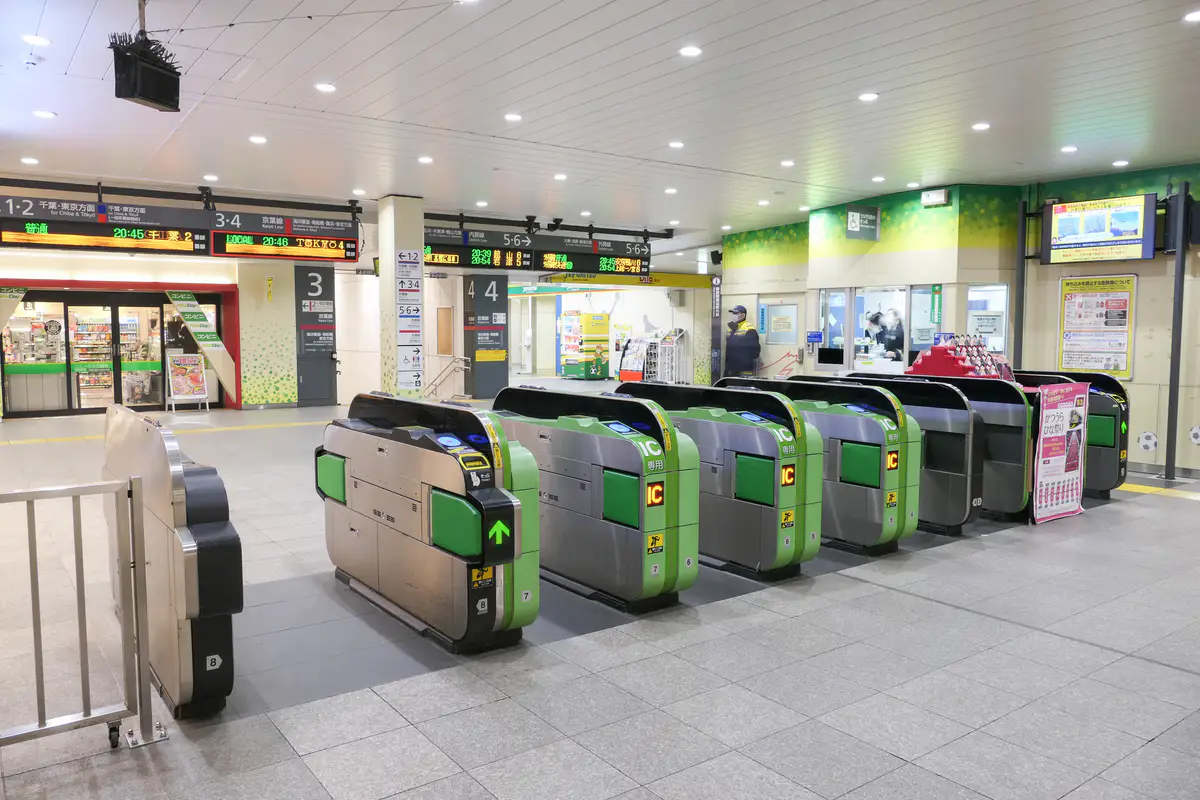 JR East station gates with illuminated IC card readers and Japanese platform signs.